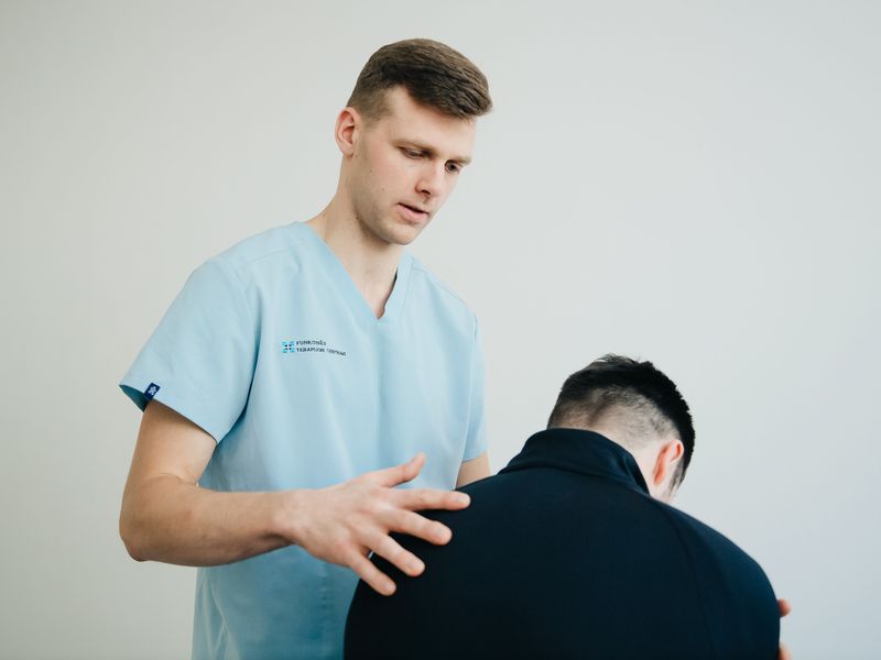 Symbolfoto: Physiotherapeut im Gespräch mit einem Patienten